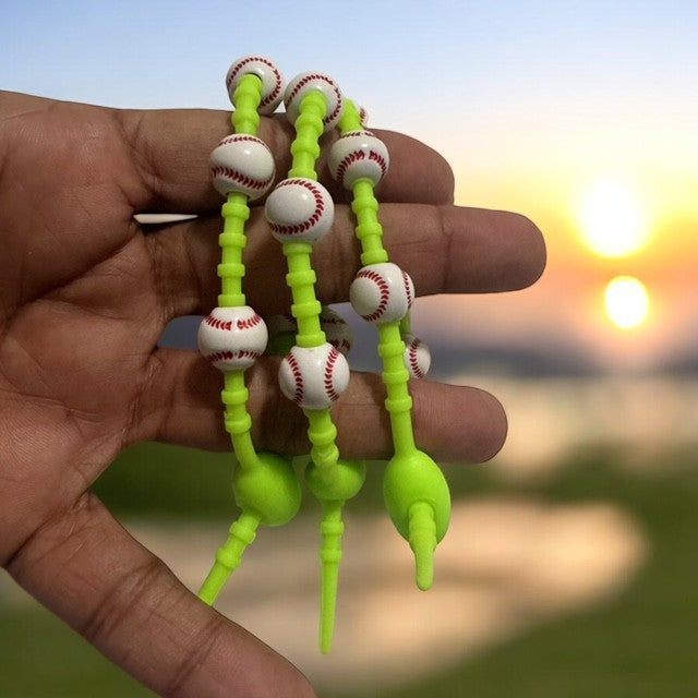 Silicone Baseball Set 3- Bracelets with Baseball-Shaped Beads held in hand at sunset with vibrant green color.