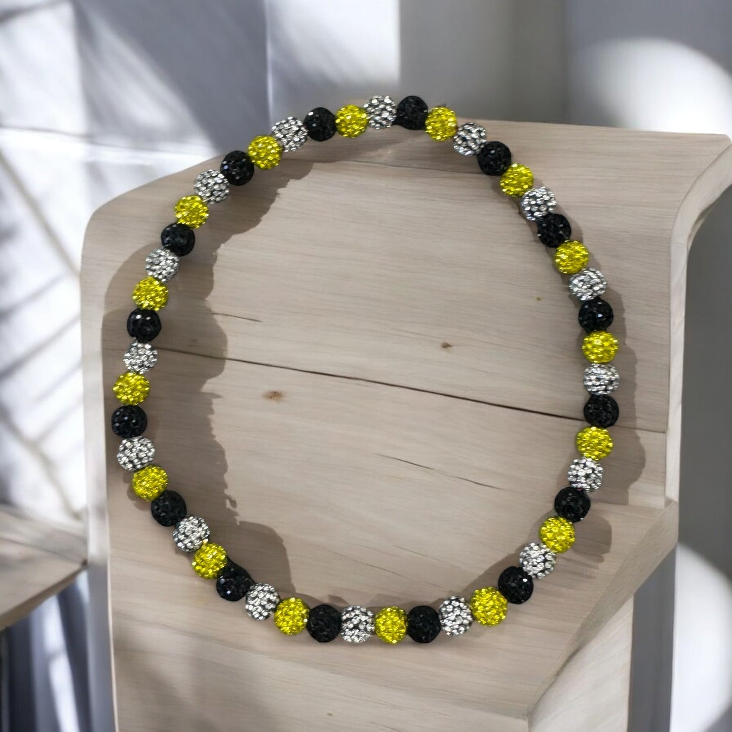 Home Plate Black Yellow 16" Baseball Necklace featuring rhinestone disco balls on a wooden display.