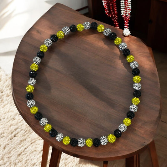 Home Plate Black Yellow 16" Baseball Necklace featuring rhinestone disco balls on a wooden table.